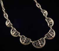 A 19th century French 18ct gold necklace, comprising nine graduated pierced scrolled panels,