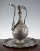 An Islamic tinned copper ewer, with scroll handle and a similar circular tray, probably Kashmir,