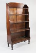 A Regency style mahogany waterfall bookcase, with five fitted shelves, arched back and turned