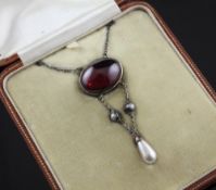 An early 20th century gold and silver, oval cabochon garnet and cultured pearl set drop pendant