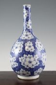 A Chinese blue and white bottle vase, 19th century, decorated with prunus blossoms on a cracked