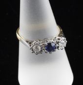 An 18ct gold, three stone sapphire and illusion set diamond ring, with round cut stones, size O.