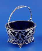 A George V pierced silver sugar basket with blue glass liner, of circular form, with gadrooned