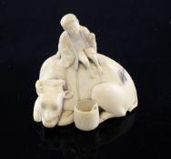 A Japanese ivory okimono of an ox and herdsman, 19th century, the boy seated upon the ox`s back, a