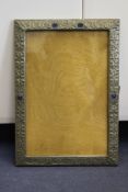 An Arts and Crafts pewter wall picture or mirror frame, with embossed scrolling decoration and
