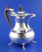 A George V silver baluster hot water pot by Elkington & Co, with wooden knop and handle, on hoof