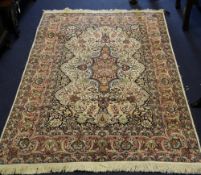 An Indian Kashmir part silk rug, with field of scrolling foliage, on a polychrome ground, with seven