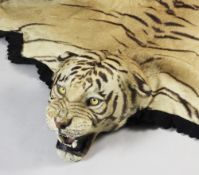 A tiger skin rug by Van Ingen & Van Ingen of Mysore, stitched with a black felt trim border, with