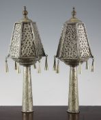 A pair of plated torah finials, the tapering hexagonal scroll panels with conical bell pendants,