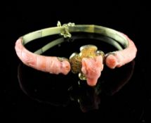 A high carat gold and carved coral mounted hinged bracelet, with engraved band and carved ram`s head