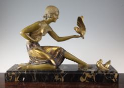 A Chiparus Art Deco patinated metal figure of a kneeling woman accompanied by two doves, on a veined
