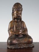 A Chinese gilt lacquered bronze seated figure of Guanyin, possibly Ming Dynasty, wearing elaborate