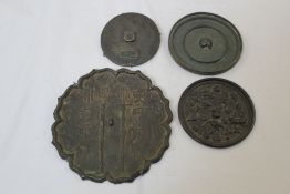 Four Chinese bronze hand mirrors, Tang Dynasty or later, the first with eight petal lobed order cast