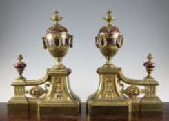 A pair of Victorian ormolu and rouge marble chenets, each mounted with a pedestal urn with swag