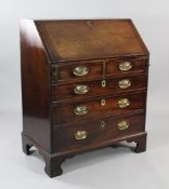 A George III mahogany bureau, the fall front revealing a fitted interior over two short and three