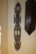 A Papua New Guinea figural food hook, with red and white painted carved decoration and cowrie