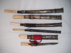 A collection of six Burmese Dha, five with scabbards, one without, all with ivory handles, largest