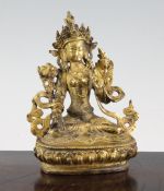 A Tibetan gilt bronze seated figure of White Tara, 18th / 19th century, seated in dhyanasana on a
