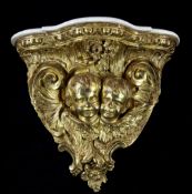 A late 19th century carved giltwood wall bracket, the serpentine top modelled as two winged