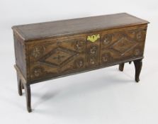A carved oak six plank coffer, with lozenge and roundel carved front and scroll front legs, W.3ft