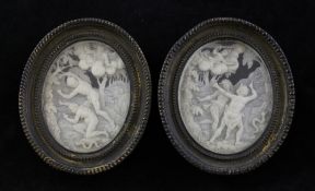 A pair of early 19th century North European carved ivory oval panels, depicting Adam and Eve in