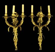 A pair of ormolu three branch wall lights, modelled as ribbons and entwined scrolls and vines,