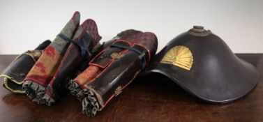 A Japanese lacquered Jingasa samurai`s helmet and two pairs of shin guards, 19th century, the