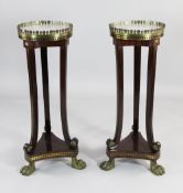 A pair of French Empire style gueridons, with white marble tops and brass and ebony inlaid