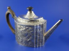 A George III Irish silver teapot, of oval form, with engraved armorial and embossed with flowers,