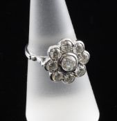 An 18ct white gold and diamond cluster ring, of flower head design, set with nine stones weighing