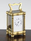 An early 20th century French gilt brass miniature carriage timepiece, with serpentine case,