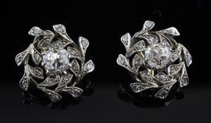 A pair of two colour gold and diamond cluster ear clips, each set with central old cut diamond