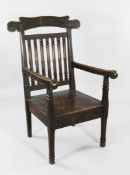 A Welsh Eisteddfod carved oak Bardic chair, initialled and dated HM 1922, with oak leaf and acorn