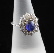 An Edwardian platinum, cabochon sapphire and diamond set cluster ring, of oval form, size J.