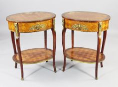 A pair of French oval two tier tables, with parquetry inlay and ormolu mounts, each fitted with a