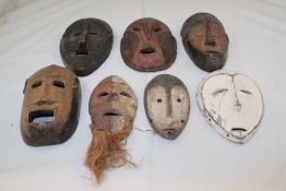 A collection of seven West African carved wall masks, some retaining original pigment, largest 11.