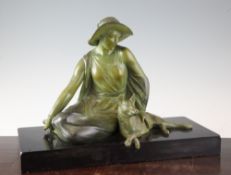A French Art Deco patinated metal figure of a seated female with alsatian dog, on a rectangular