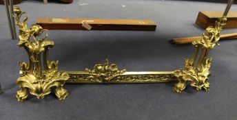 A late 19th century gilt bronze fender, in the Art Nouveau style, comprising a pair of chenet and