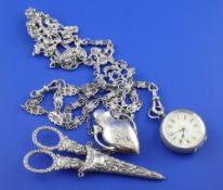 A late Victorian silver chatelaine, pierced and decorated with figures, scrolls and mask links,
