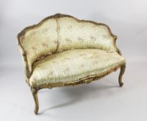 A Louis XV style carved giltwood canapé, with floral upholstery and acanthus and C scroll frame