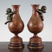 After Augustus Moreau. A pair of French patinated bronze vases, each mounted with winged cherubs and