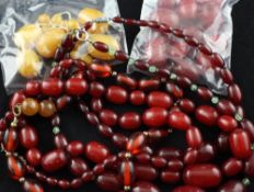 Five single strand graduated simulated red amber bead necklaces and a quantity of loose beads,