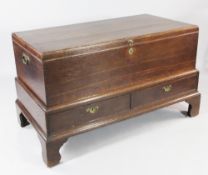 A large 18th century oak box on stand, with brass side handles and two drawers below, on bracket