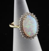 An 18ct gold, white opal and diamond cluster ring, of oval form, with diamond set border, size F.