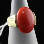 An Italian 18ct gold and cabochon coral set ring, of oval form, size M.