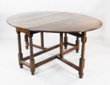 An 18th century walnut and oak oval gateleg table, with turned supports united by stretchers, W.