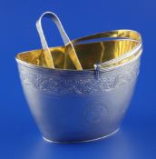A George III silver oval sugar basket, with engraved foliate band, armorial and reeded border and