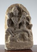An Indian grey limestone stele, possibly 10th century AD, carved in relief with Shiva next to his