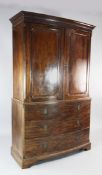 A George III style mahogany bowfront linen press, fitted two panelled doors enclosing four sliding