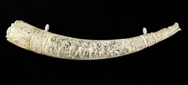 A 19th century German carved ivory oliphant, the mouthpiece carved as the head of a mythical beast